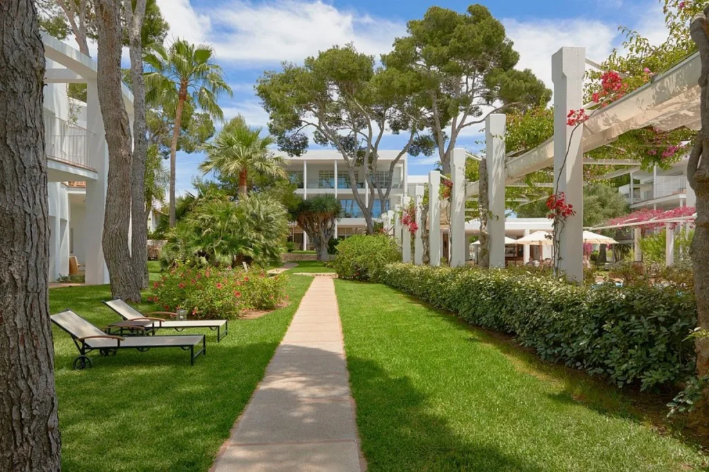 Landscaped garden path surrounded by Mediterranean greenery at Meliá Cala d'Or Boutique Hotel in Cala d'Or, Mallorca.