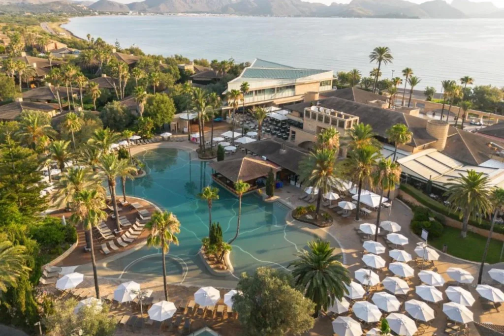Aerial view of the lagoon-style pool and bay at PortBlue Club Pollentia Resort & Spa in Pollença, Mallorca
