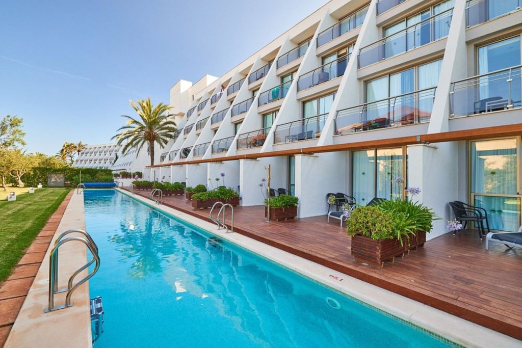 Swimming pool bordered by ground-floor terrace rooms at Protur Sa Coma Playa Hotel & Spa in Sa Coma, Mallorca.