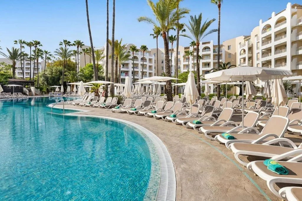 Lagoon-style swimming pool with sun loungers at Protur Safari Park Aparthotel in Sa Coma, Mallorca