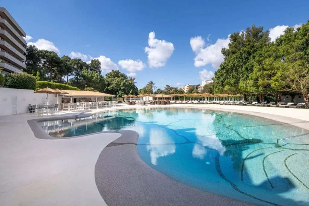 Outdoor pool area with sun loungers at Sallés Hotel Marina Portals in Portals Nous, Mallorca.