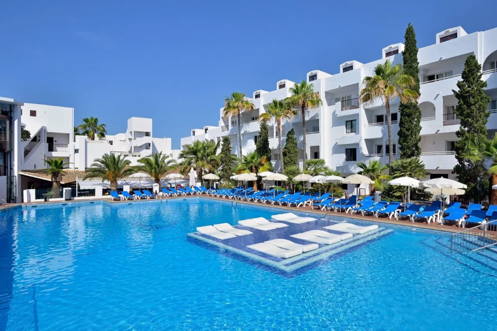 Main outdoor swimming pool with in-water sun loungers at Sol Cala D’Or Apartments in Cala d’Or, Majorca.