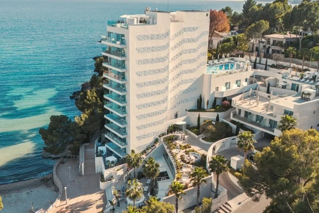 Modern beachfront hotel exterior overlooking the Mediterranean Sea at The Donna Portals in Mallorca, Spain.