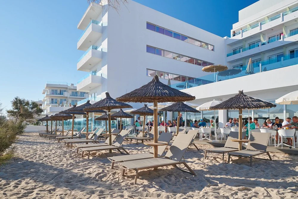 Beachfront sun terrace, sun loungers, parasols, and modern hotel building at The Sea Hotel by Grupotel (Adults Only) in Can Picafort