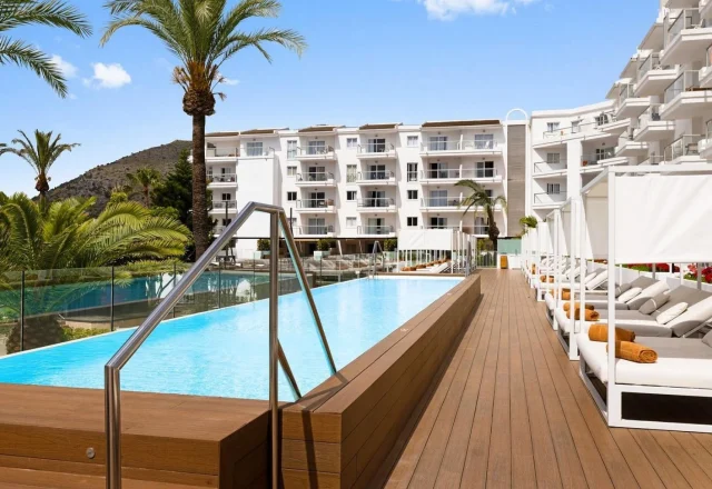 Infinity pool with luxury sun loungers and private cabanas at VIVA Sunrise in Puerto Alcudia, Majorca.