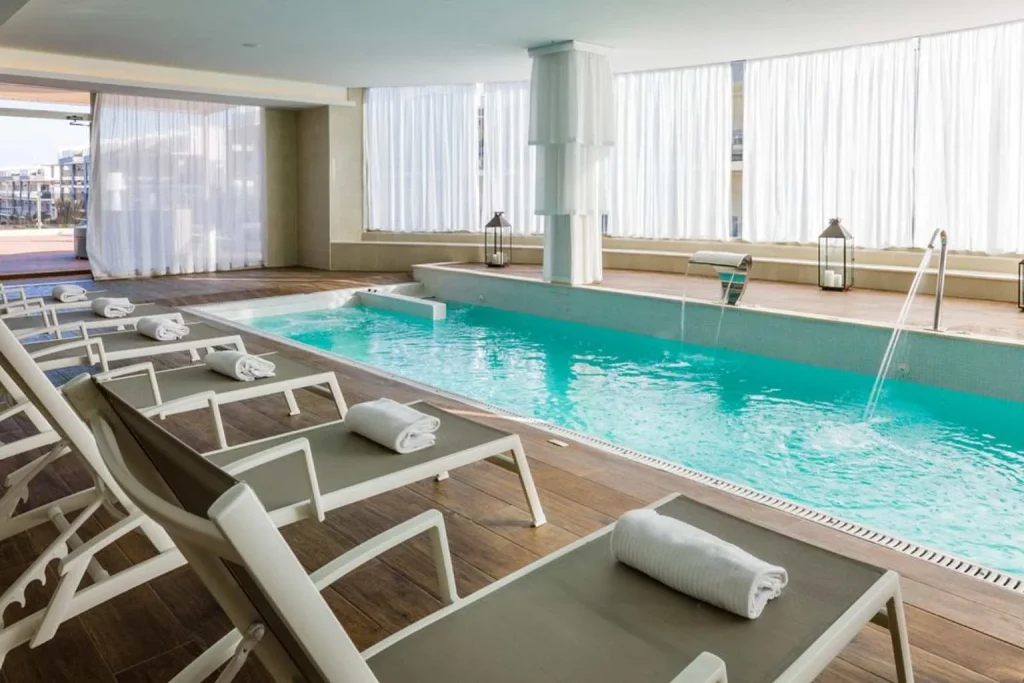 The indoor spa at Zafiro Palace Alcudia offers a heated wellness pool, hydrotherapy jets, comfortable loungers, and a bright, modern space designed for relaxation.
