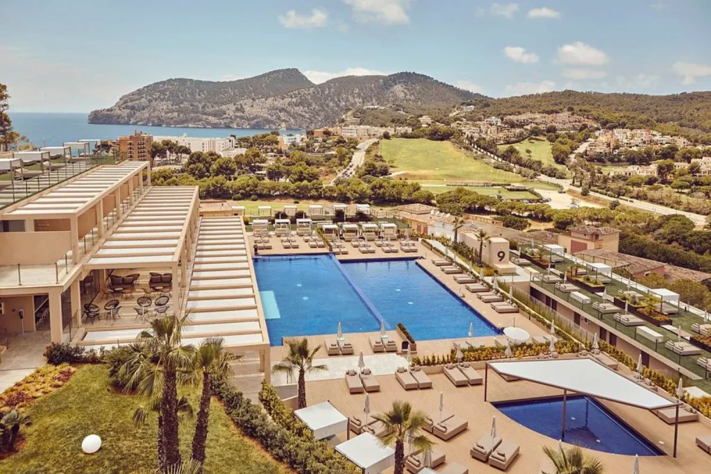 Panoramic view of the main outdoor pool, sun terraces, and surrounding hills at Zafiro Palace Andratx in Camp de Mar, Mallorca.