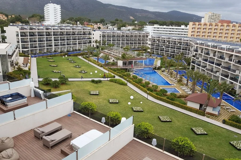 Panoramic view of multiple swimming pools, landscaped gardens, and modern resort buildings at Zafiro Palace Palmanova in Palmanova.